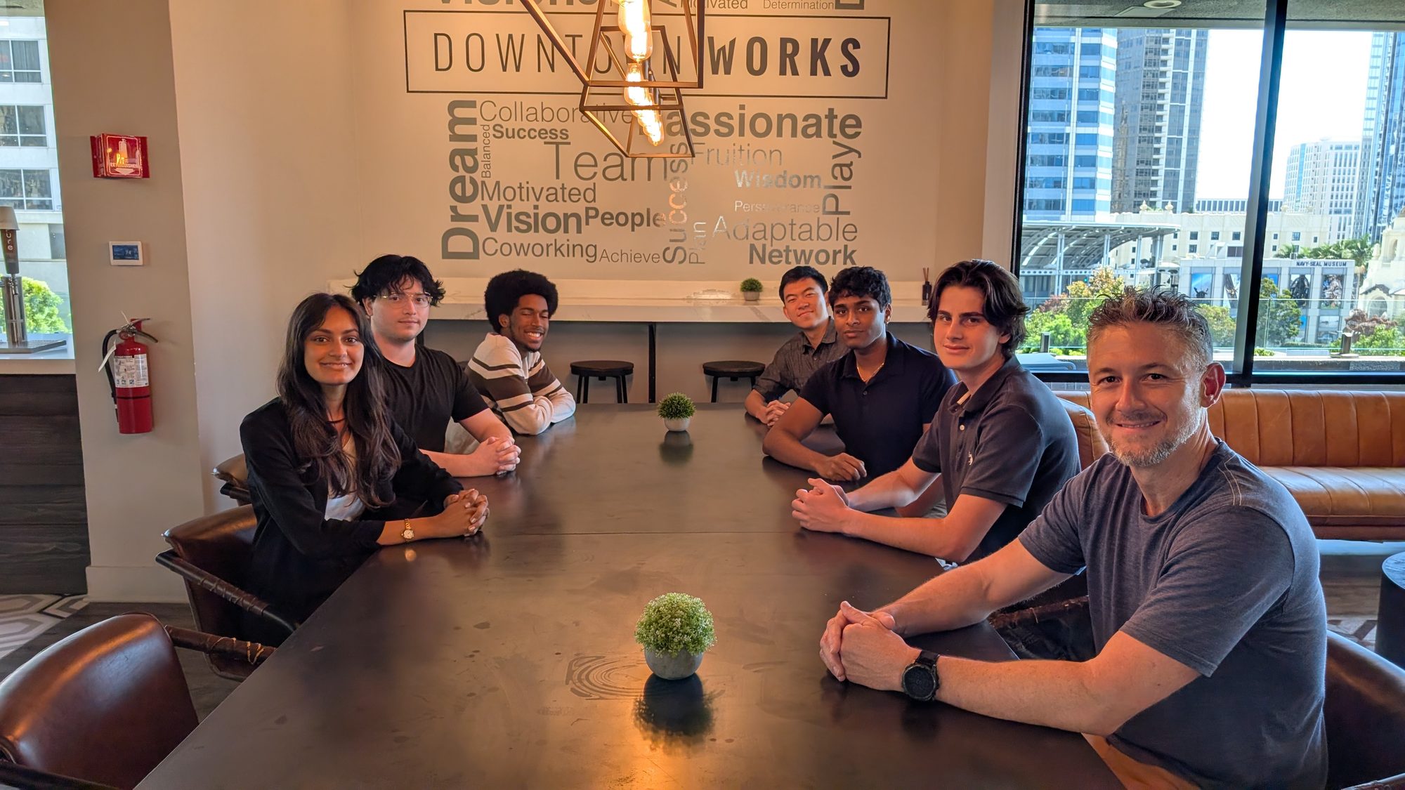 The Flashlight 3D founder and six-person summer intern cohort seated together around a conference table in San Diego.